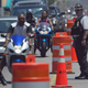 Motorcyclists ride down Ocean Boulevard in Myrtle Beach, S.C., under the watchful eye of a local law enforcement officer on May 27, 2005, during “Black Bike Week.”